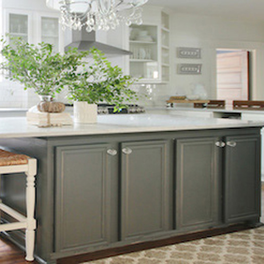 Dark green-grey lower cabinets with a white marble countertop.